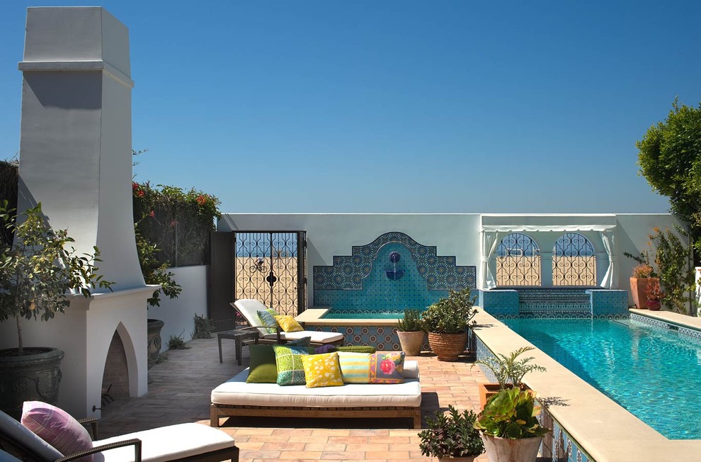 Exemple d'une terrasse méditerranéenne avec un foyer extérieur.