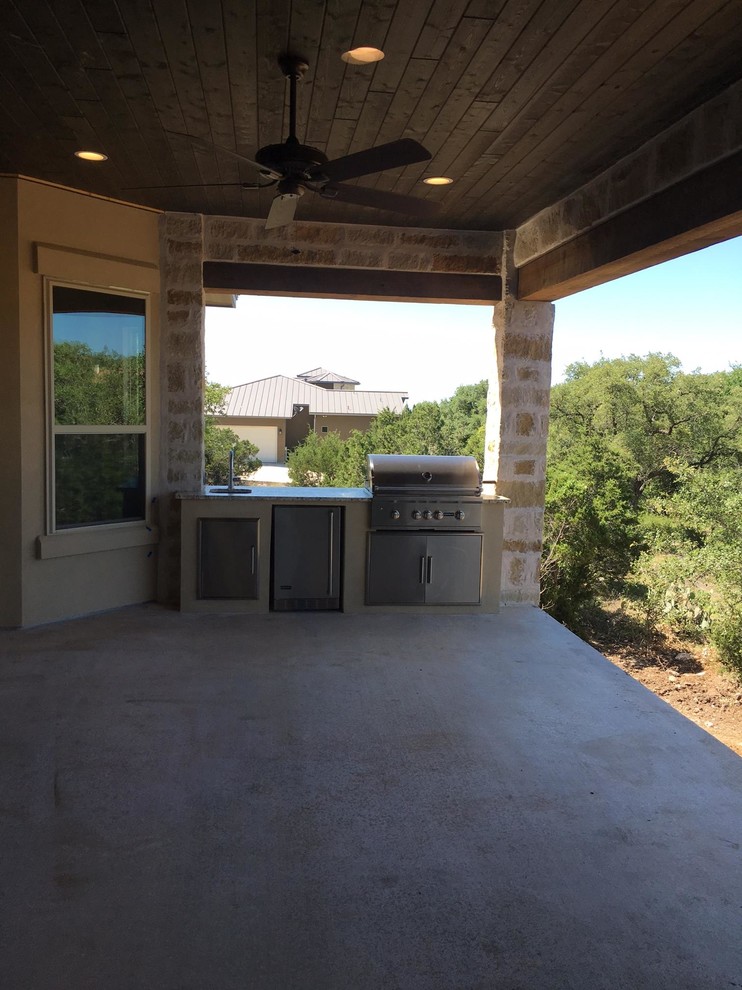 Cette image montre une terrasse arrière traditionnelle de taille moyenne avec une cuisine d'été, une dalle de béton et une extension de toiture.