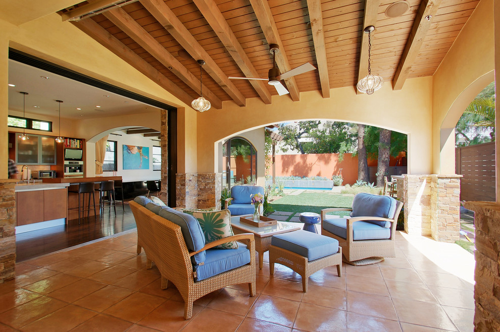 Inspiration for a large mediterranean backyard patio remodel in Los Angeles with a roof extension