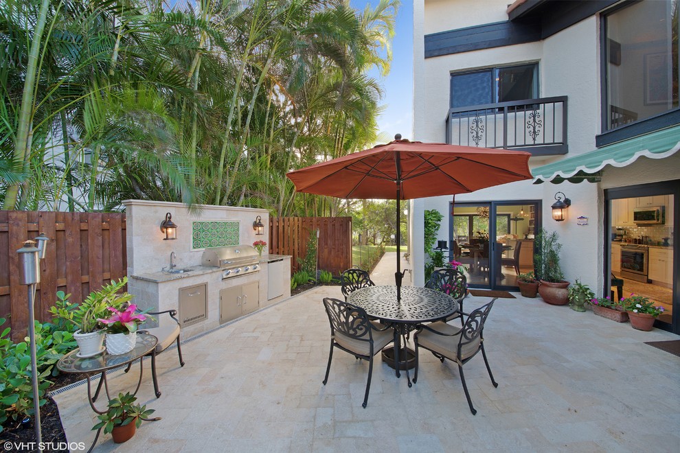 Idee per un patio o portico costiero di medie dimensioni e in cortile con pavimentazioni in pietra naturale e un parasole