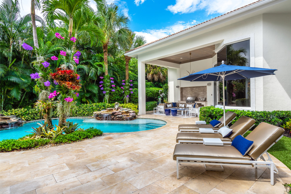Großer, Überdachter Klassischer Patio hinter dem Haus mit Wasserspiel und Natursteinplatten in Miami