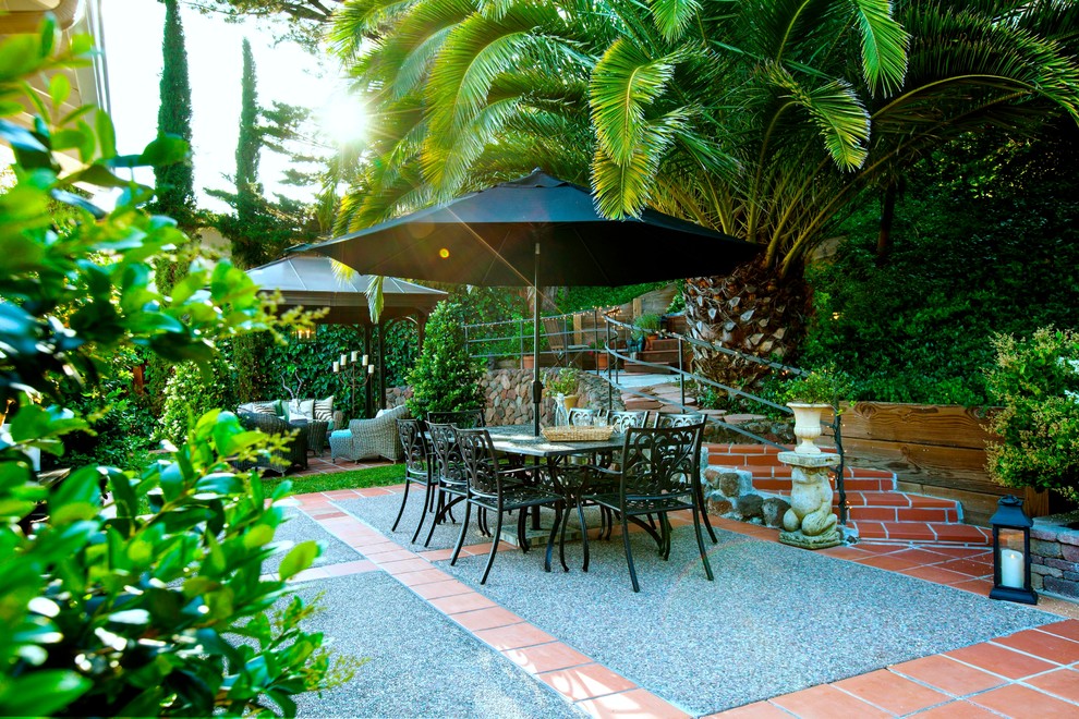 Immagine di un ampio patio o portico mediterraneo dietro casa con un gazebo o capanno