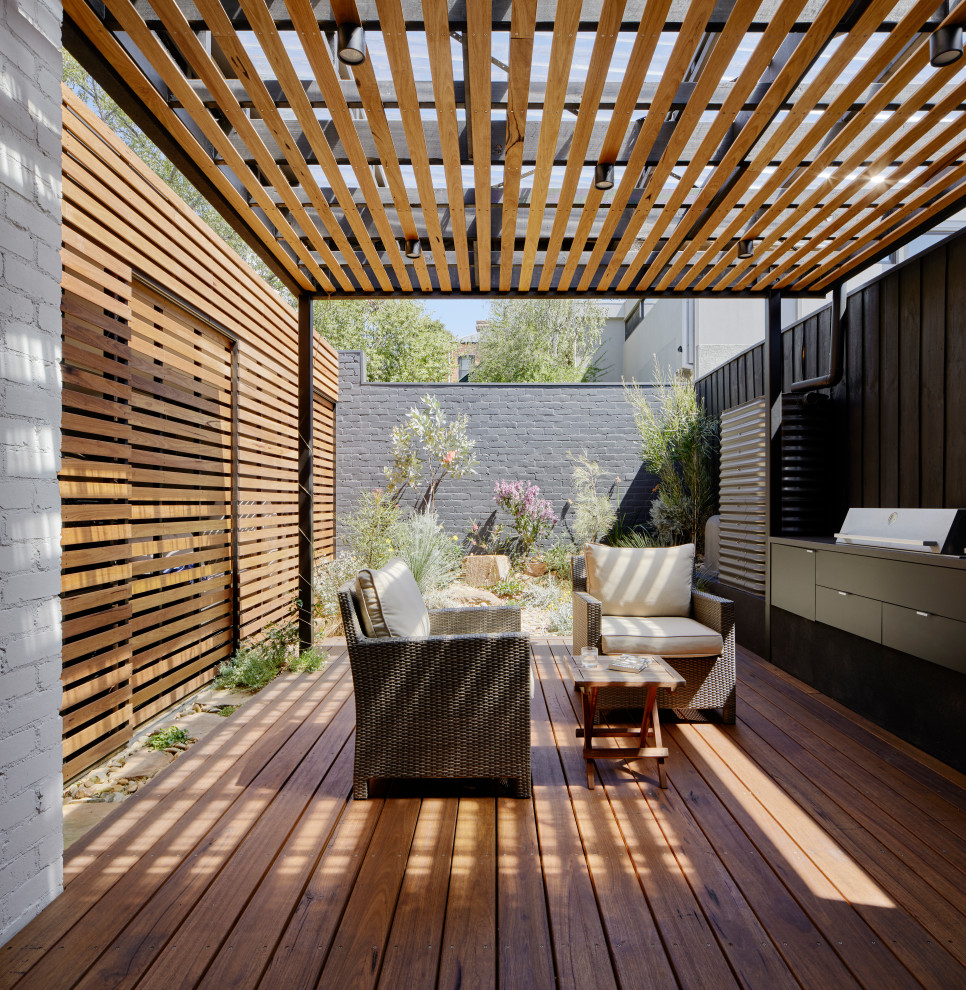 This is an example of a small modern back patio in Melbourne with decking and a pergola.