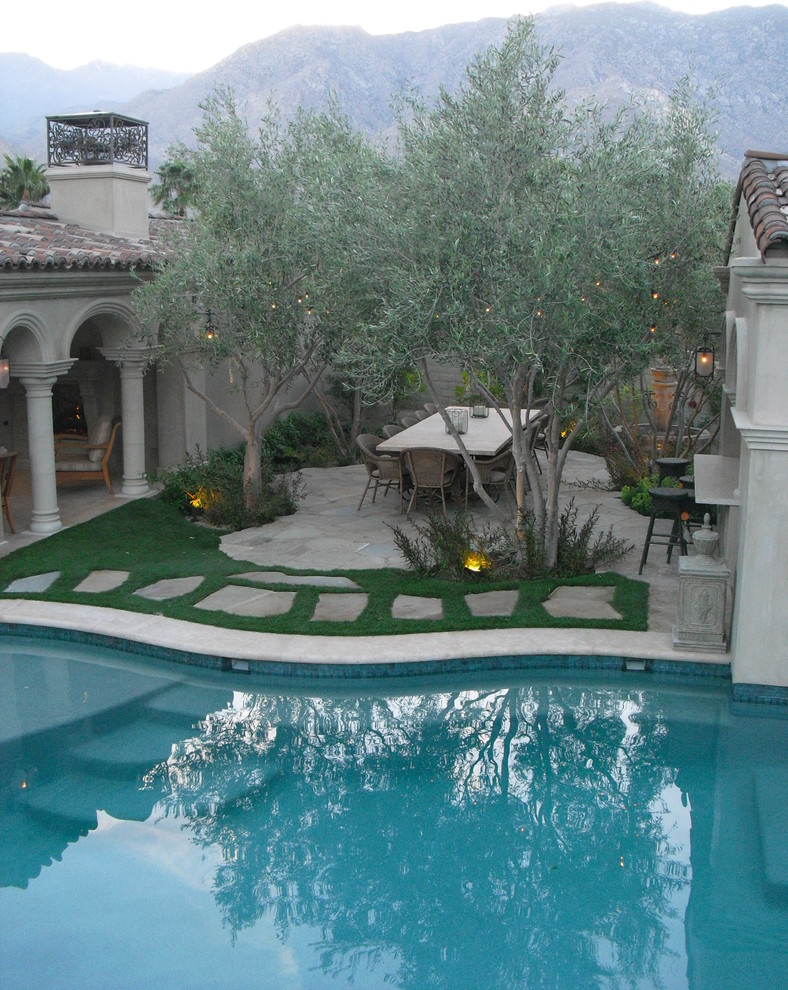 Foto di un ampio patio o portico mediterraneo in cortile con un focolare e una pergola