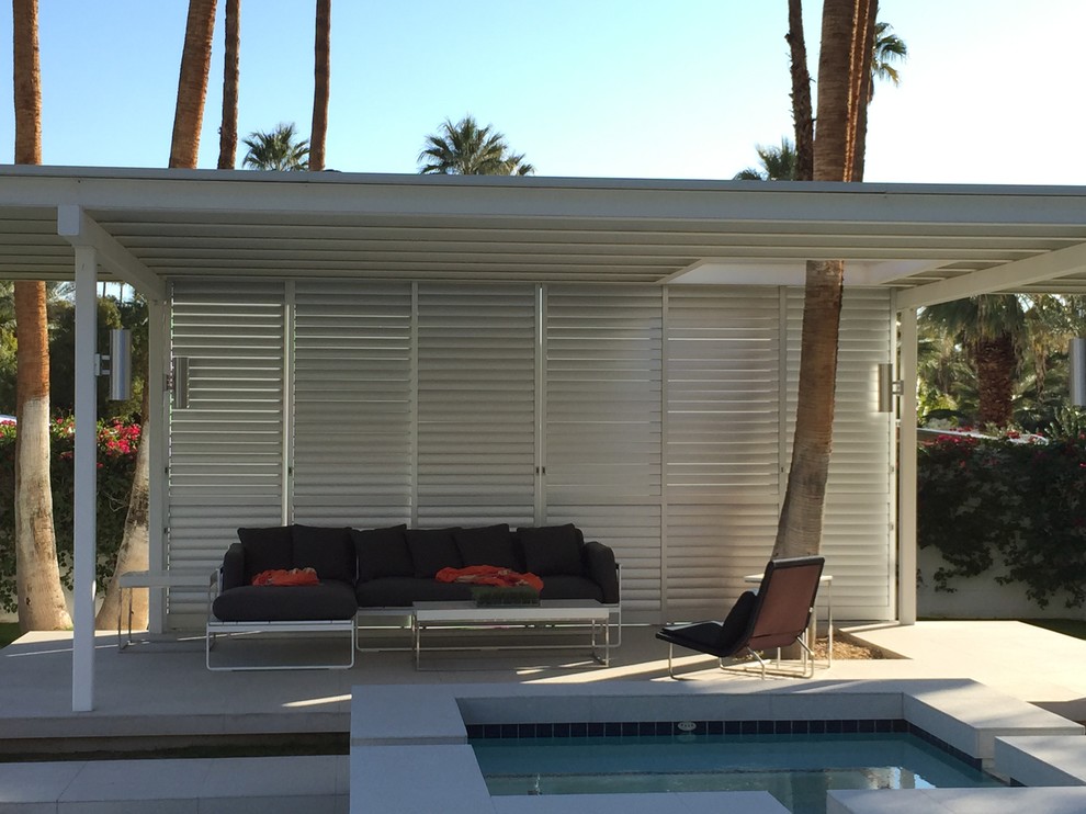 Inspiration pour une terrasse arrière minimaliste avec une dalle de béton et un gazebo ou pavillon.