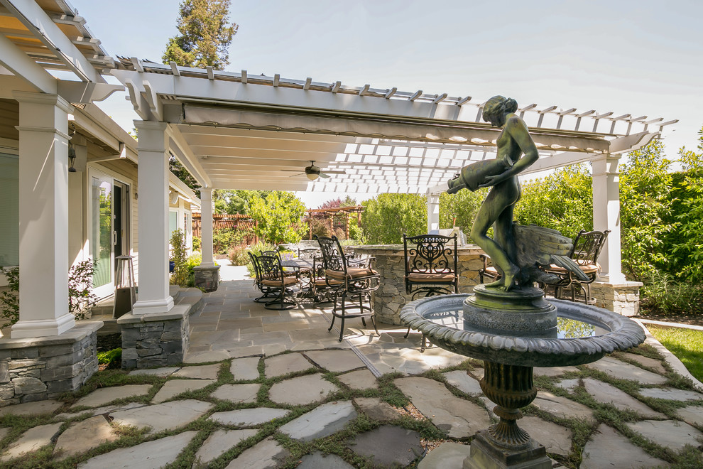 Inspiration for a mid-sized transitional backyard stone patio fountain remodel in San Francisco with a pergola