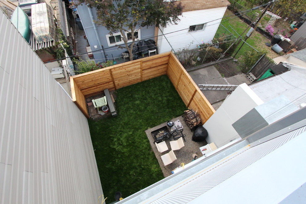 Exemple d'une terrasse en bois arrière industrielle de taille moyenne avec un foyer extérieur et aucune couverture.