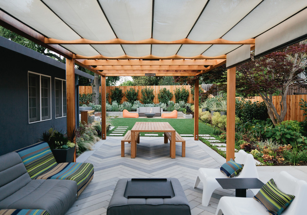 Aménagement d'une terrasse arrière contemporaine de taille moyenne avec des pavés en béton et une pergola.