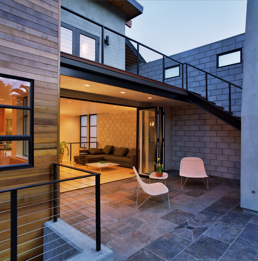 Cette photo montre une terrasse arrière tendance avec un foyer extérieur.