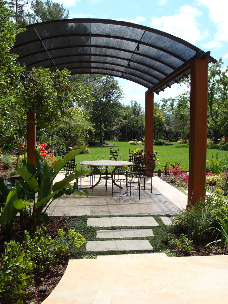 Idee per un grande patio o portico mediterraneo dietro casa con pavimentazioni in cemento e un gazebo o capanno