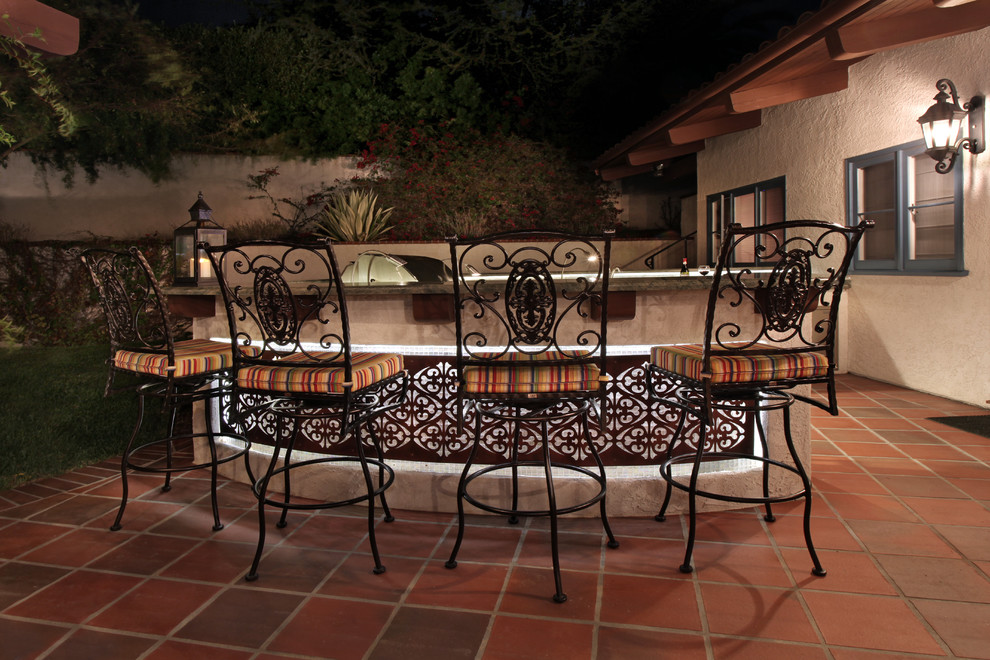 Cette image montre une grande terrasse arrière méditerranéenne avec une cuisine d'été, du carrelage et une pergola.