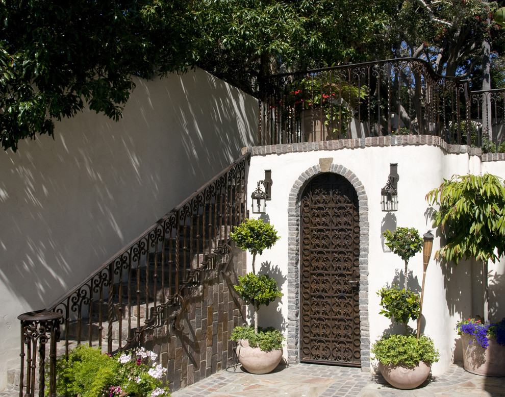 Großer, Unbedeckter Mediterraner Patio hinter dem Haus mit Kübelpflanzen und Natursteinplatten in San Diego