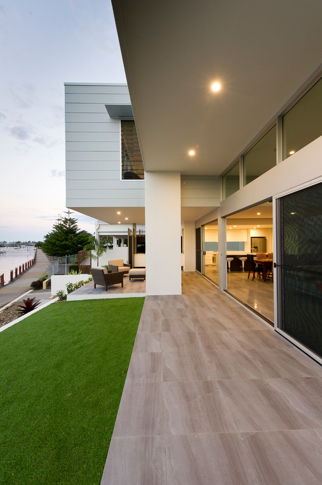 Идея дизайна: большой двор на боковом дворе в современном стиле с навесом и покрытием из плитки