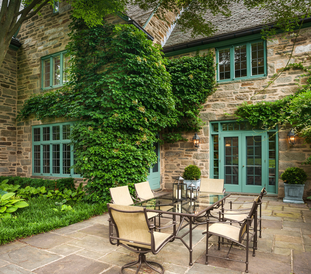 Imagen de patio clásico sin cubierta en patio trasero con adoquines de piedra natural