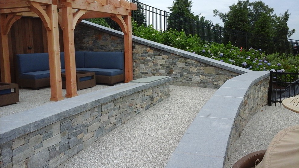 Idées déco pour une terrasse arrière classique avec un foyer extérieur, des pavés en pierre naturelle et un gazebo ou pavillon.