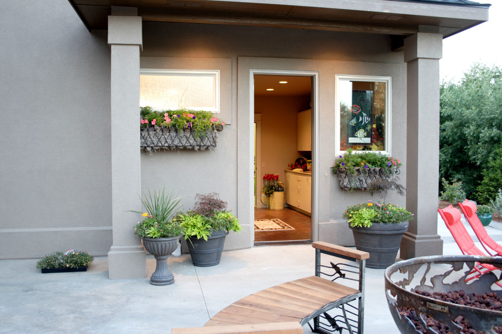 Inspiration for a large classic back patio in Boise with a fire feature, concrete slabs and a roof extension.
