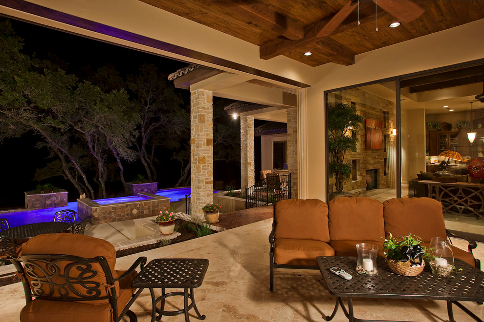Patio - large contemporary backyard stone patio idea in Austin with a roof extension