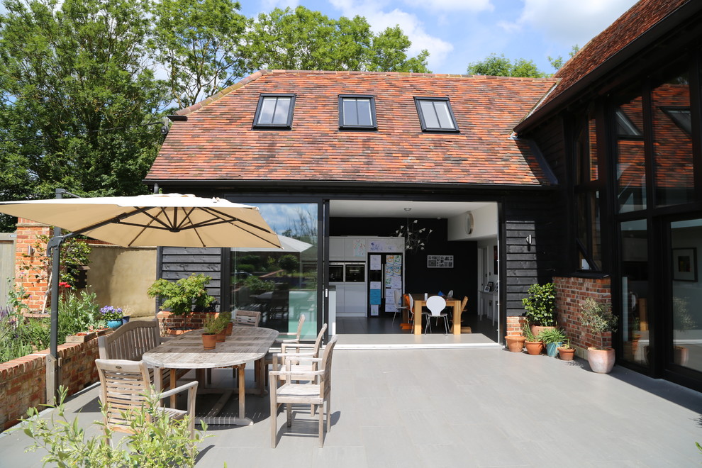 Inspiration for a large contemporary back patio in Buckinghamshire with an outdoor kitchen, concrete slabs and no cover.