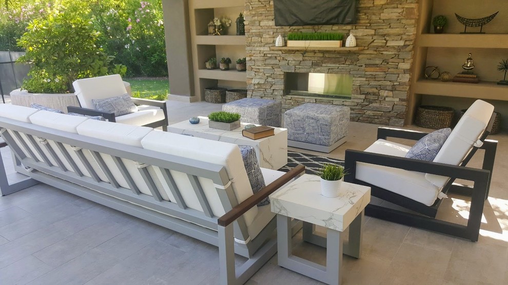 Design ideas for a large modern back patio in Phoenix with a fireplace, concrete paving and a roof extension.