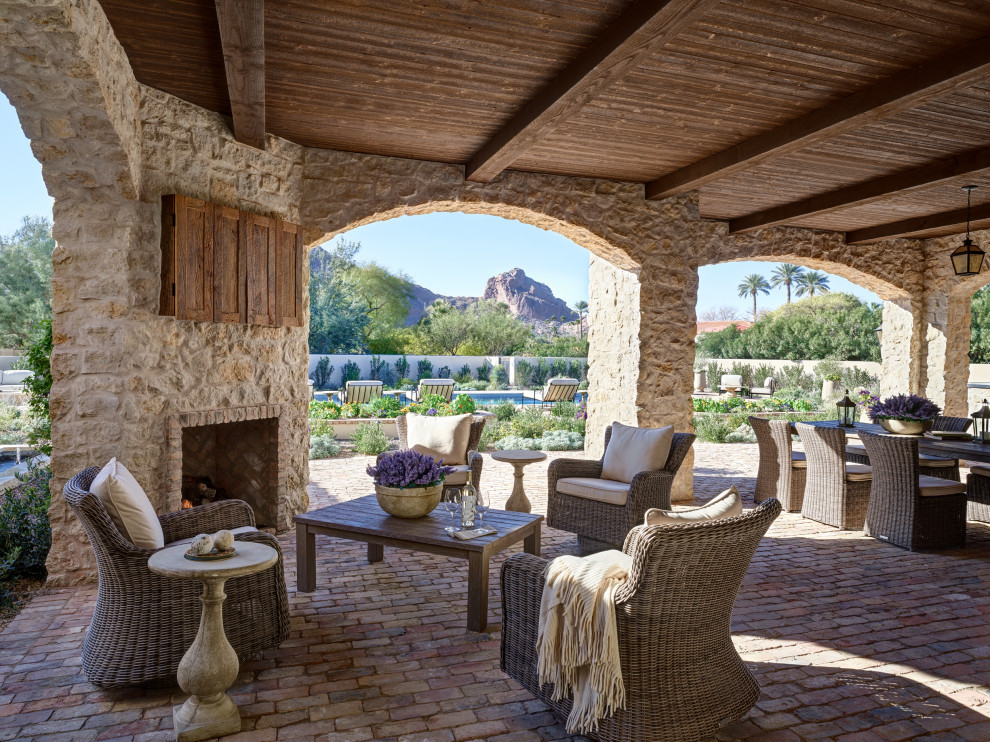 Inspiration pour une terrasse arrière méditerranéenne avec une cheminée, du carrelage et une extension de toiture.
