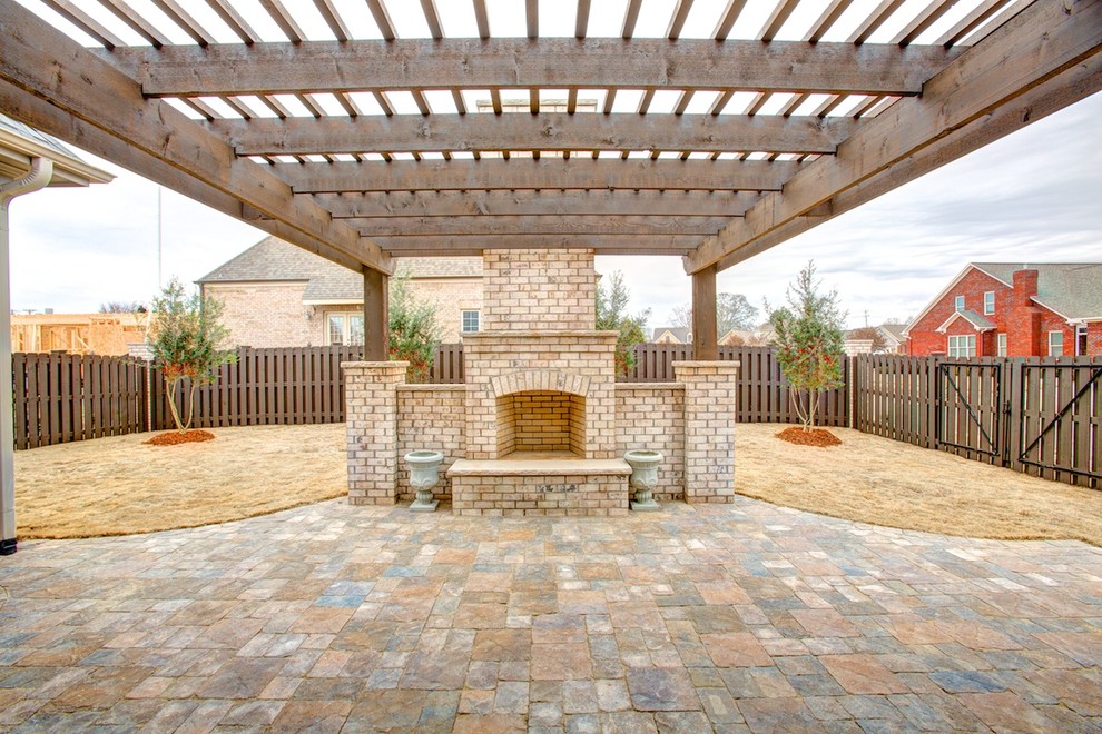 Esempio di un patio o portico mediterraneo di medie dimensioni e dietro casa con un focolare, pavimentazioni in pietra naturale e una pergola