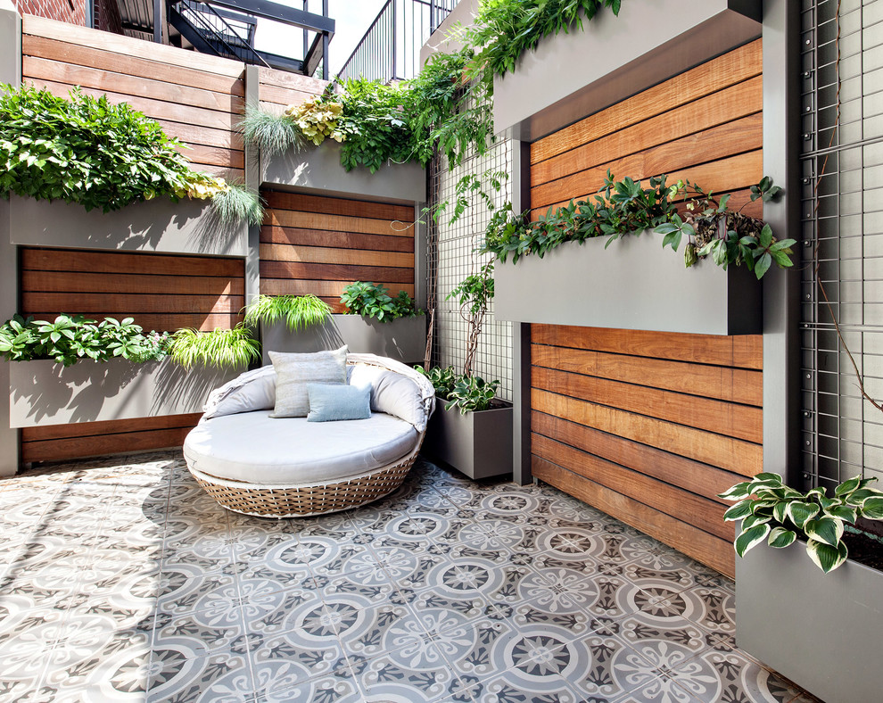 Idée de décoration pour un mur végétal de terrasse design de taille moyenne avec une cour, du carrelage et aucune couverture.