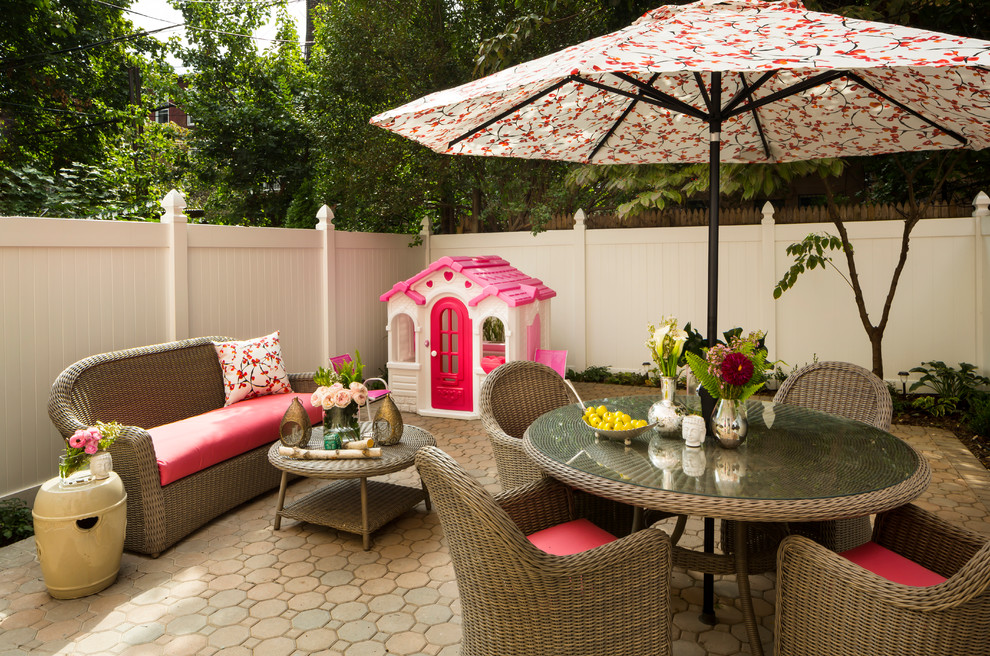 Immagine di un patio o portico chic di medie dimensioni e dietro casa con pavimentazioni in cemento e un parasole