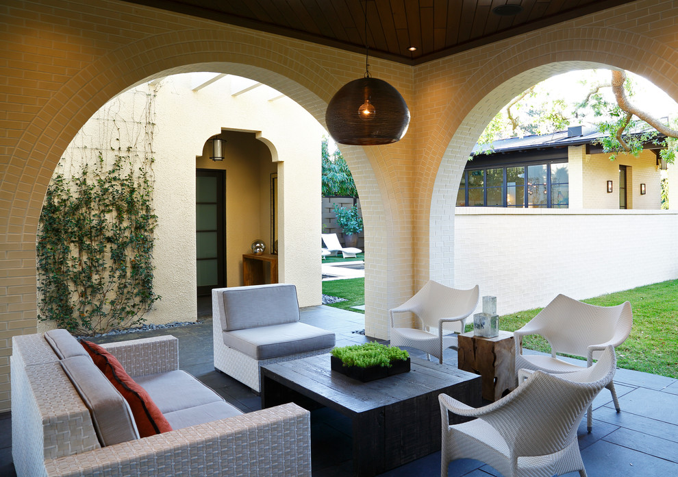 Esempio di un piccolo patio o portico minimal dietro casa con piastrelle e un tetto a sbalzo
