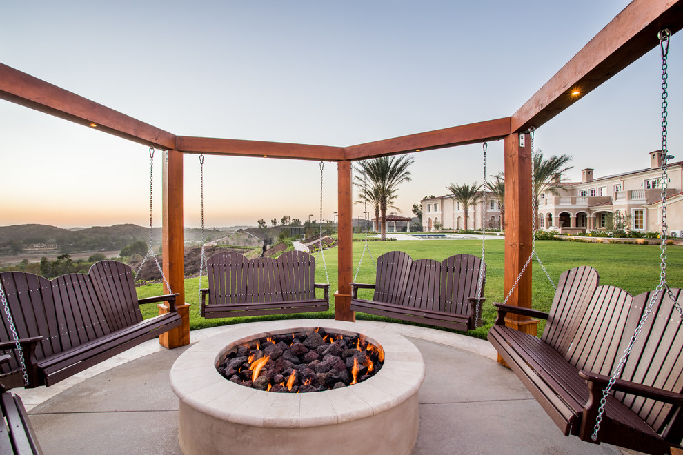 Traditional back patio in Orange County with a fire feature, concrete slabs and no cover.