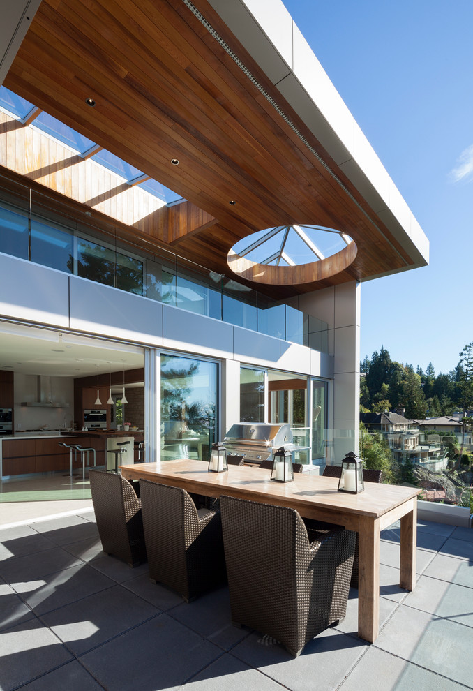 Photo of a contemporary patio in Vancouver with a roof extension and a bbq area.