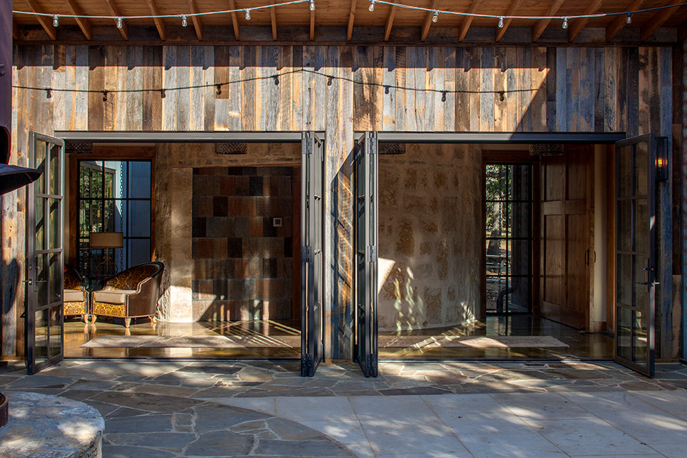 This is an example of a rustic patio in Austin with a roof extension.