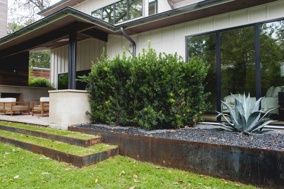 Esempio di un patio o portico minimalista di medie dimensioni e dietro casa con un focolare, piastrelle e un tetto a sbalzo