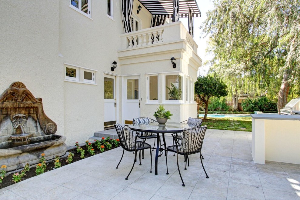 Unbedeckter Klassischer Patio hinter dem Haus mit Wasserspiel und Betonboden in Los Angeles
