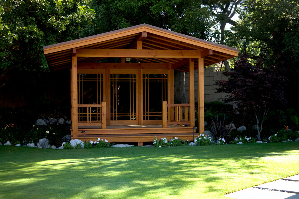 Immagine di un patio o portico moderno di medie dimensioni e dietro casa con pedane e un gazebo o capanno