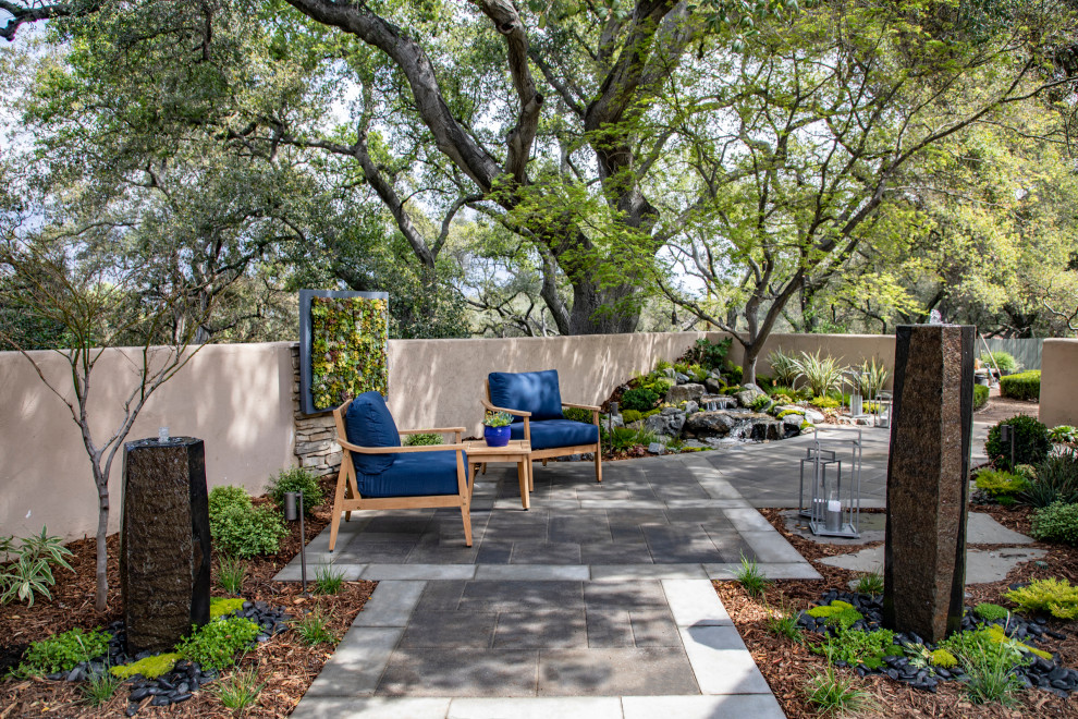 Inspiration for a small world-inspired side patio in Los Angeles with a water feature, concrete paving and no cover.
