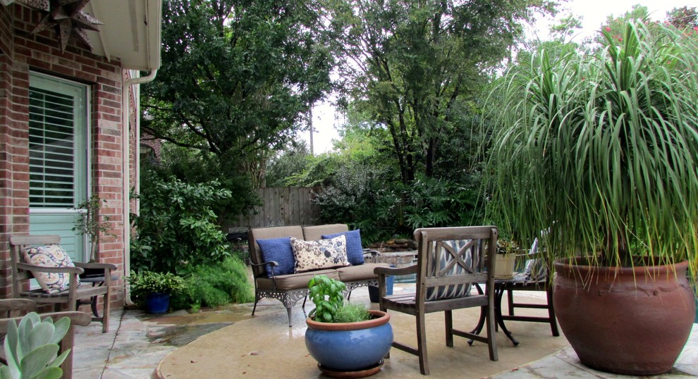 Large world-inspired back patio in Houston with decking, a water feature and a roof extension.