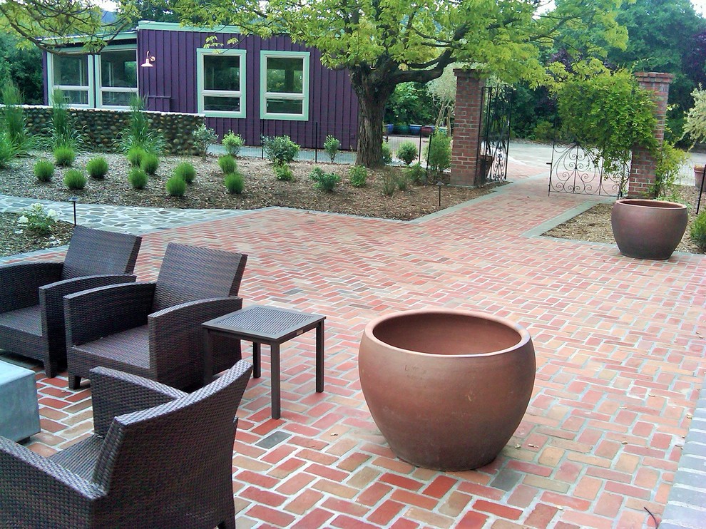 Ejemplo de patio minimalista de tamaño medio en patio trasero con adoquines de ladrillo