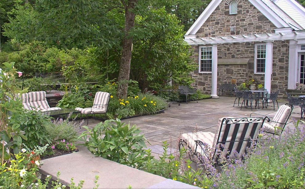 Idee per un grande patio o portico classico dietro casa con pavimentazioni in cemento e una pergola