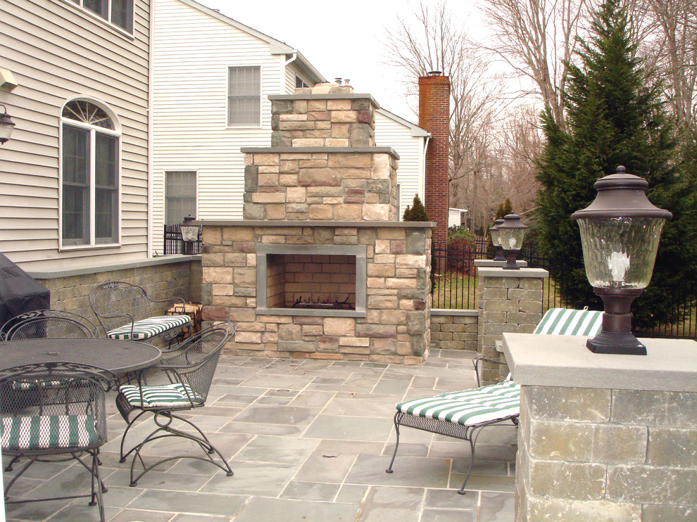 Patio - mid-sized traditional backyard stone patio idea in New York with a fire pit and no cover