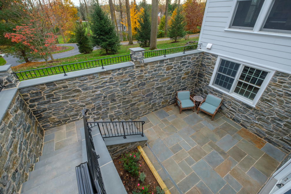 Photo of a large traditional back patio in Philadelphia with natural stone paving.