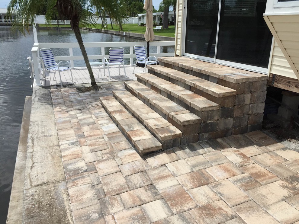 Design ideas for a large coastal back patio in Tampa with brick paving.