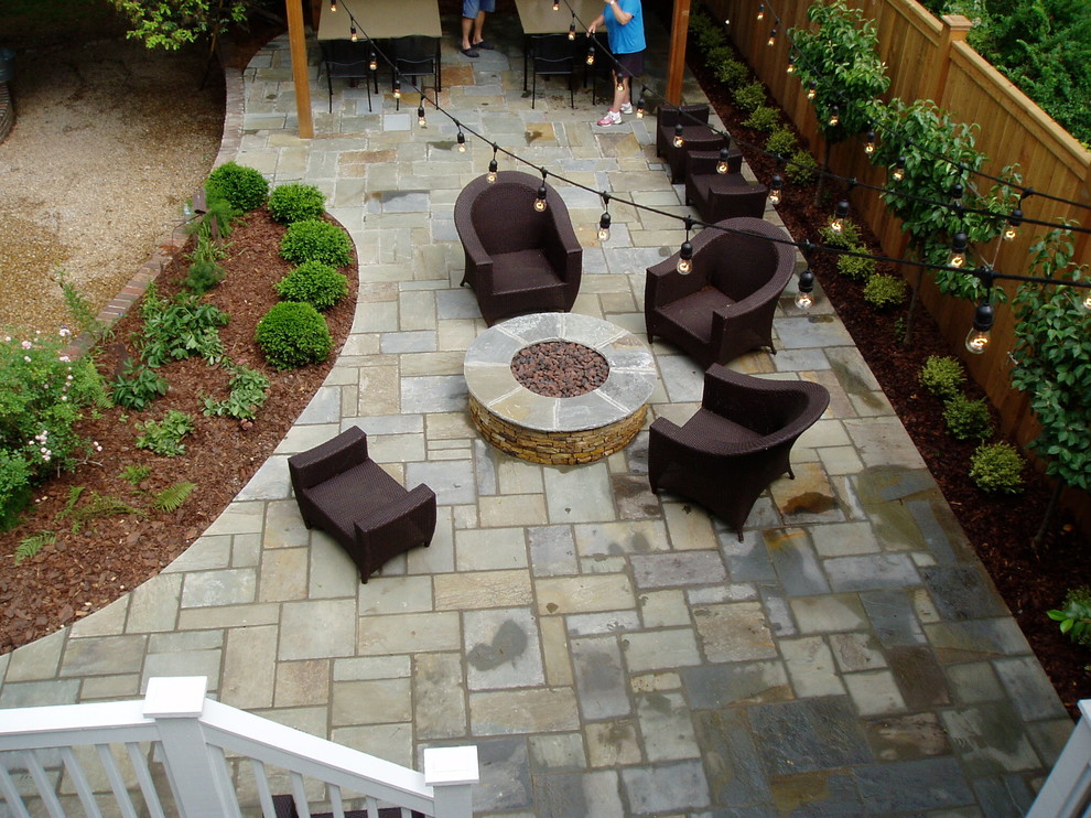 Immagine di un patio o portico stile americano dietro casa con un focolare e pavimentazioni in pietra naturale