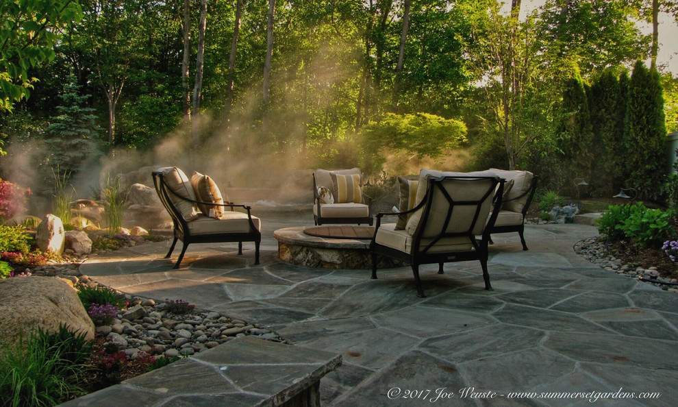 На фото: двор среднего размера на заднем дворе в классическом стиле с местом для костра и покрытием из каменной брусчатки