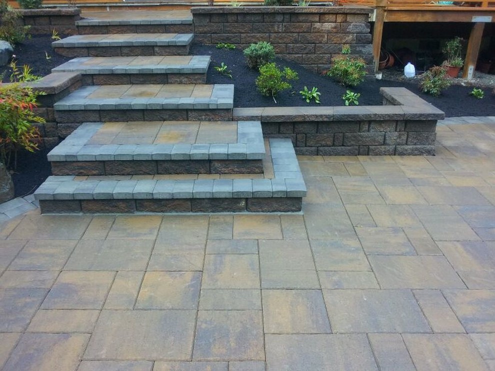 This is an example of a medium sized classic back patio in Portland with concrete paving and no cover.