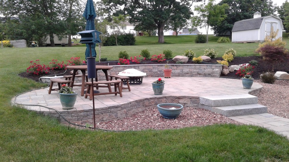 Patio - mid-sized traditional backyard concrete paver patio idea in New York with no cover and a fire pit