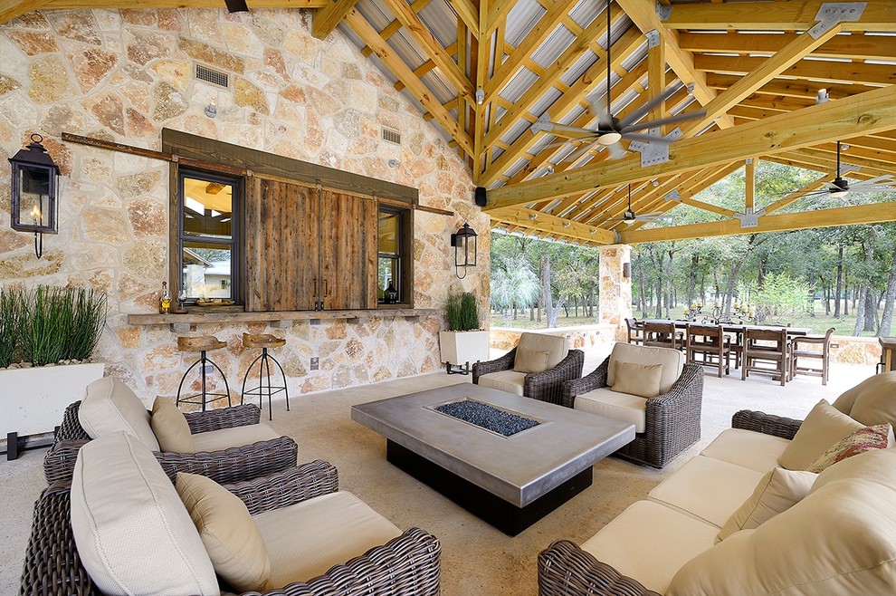 Design ideas for an expansive back patio in Houston with a fire feature, concrete slabs and a roof extension.