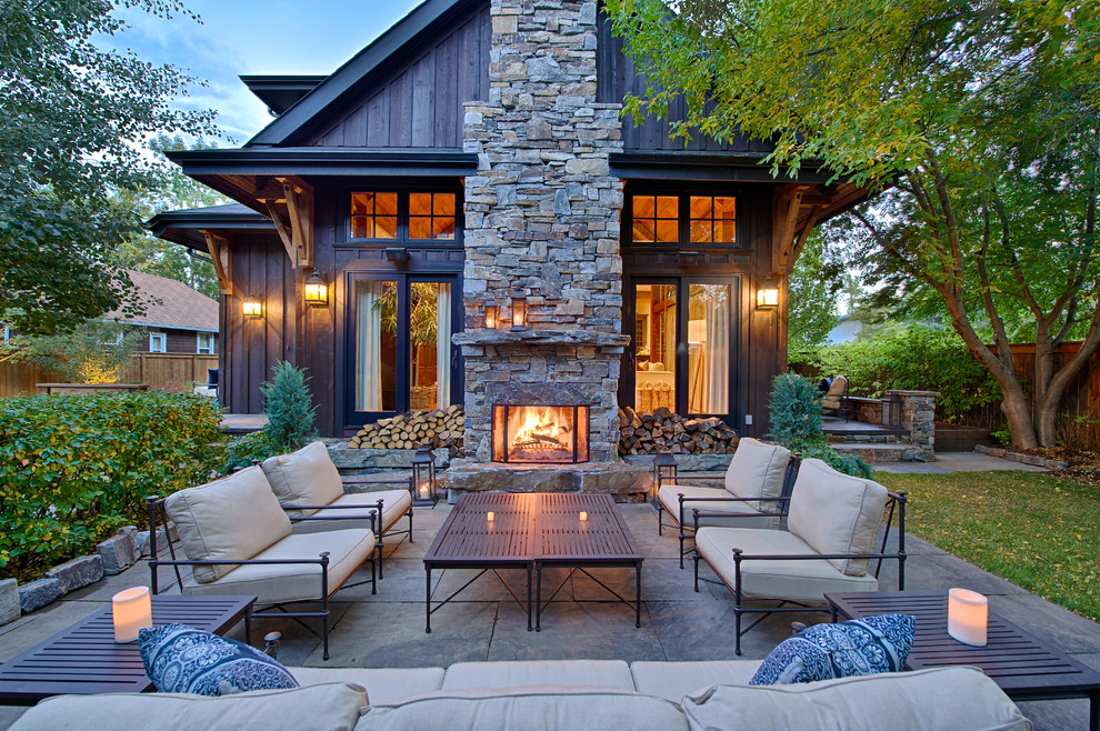 Inspiration pour une terrasse arrière traditionnelle de taille moyenne avec aucune couverture, des pavés en béton et une cheminée.