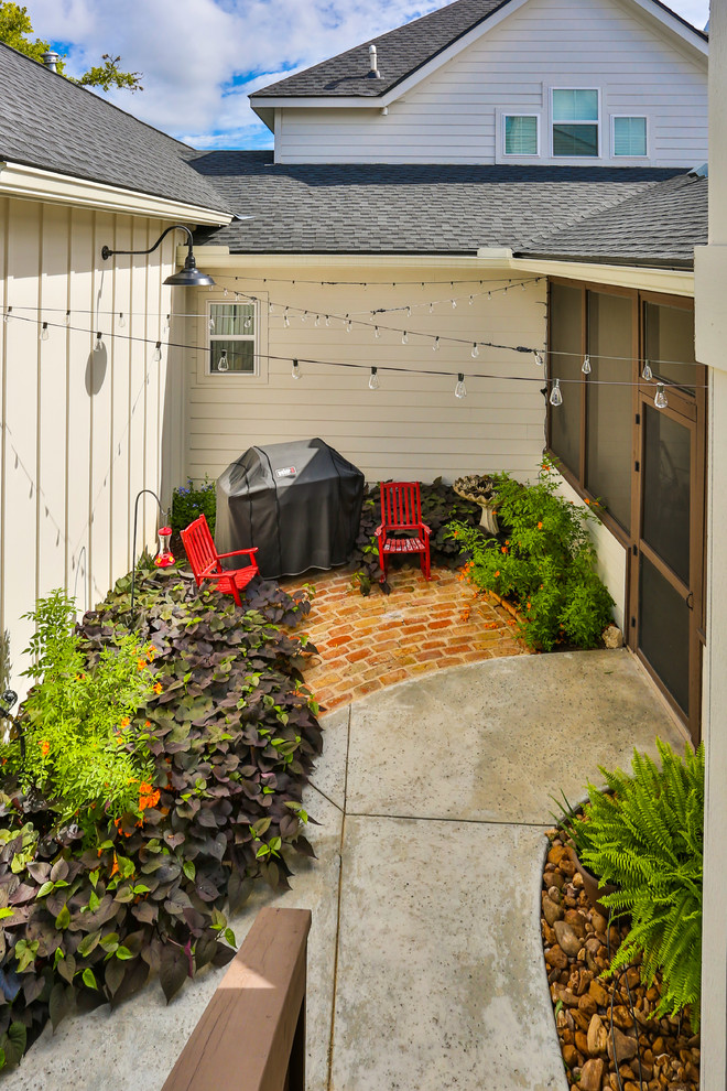 На фото: двор среднего размера на заднем дворе в классическом стиле с уличным камином, покрытием из плитки и навесом с