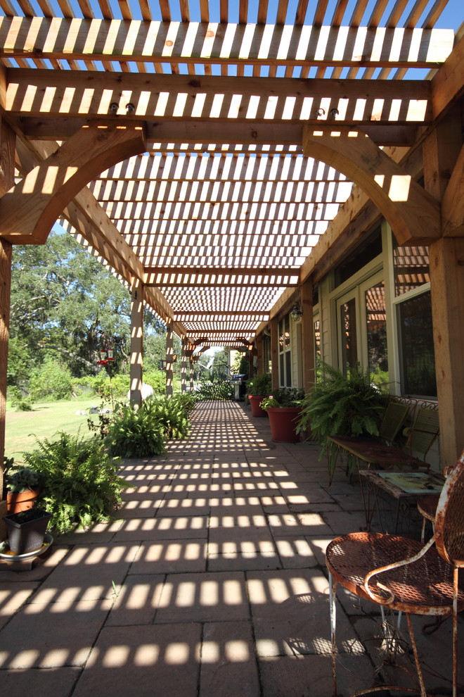 Inspiration for a country backyard brick patio remodel in Houston with a pergola
