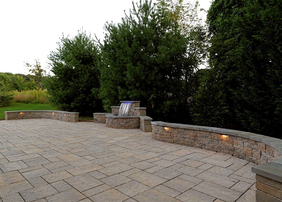 Photo of a large traditional back patio in DC Metro with a water feature, natural stone paving and no cover.
